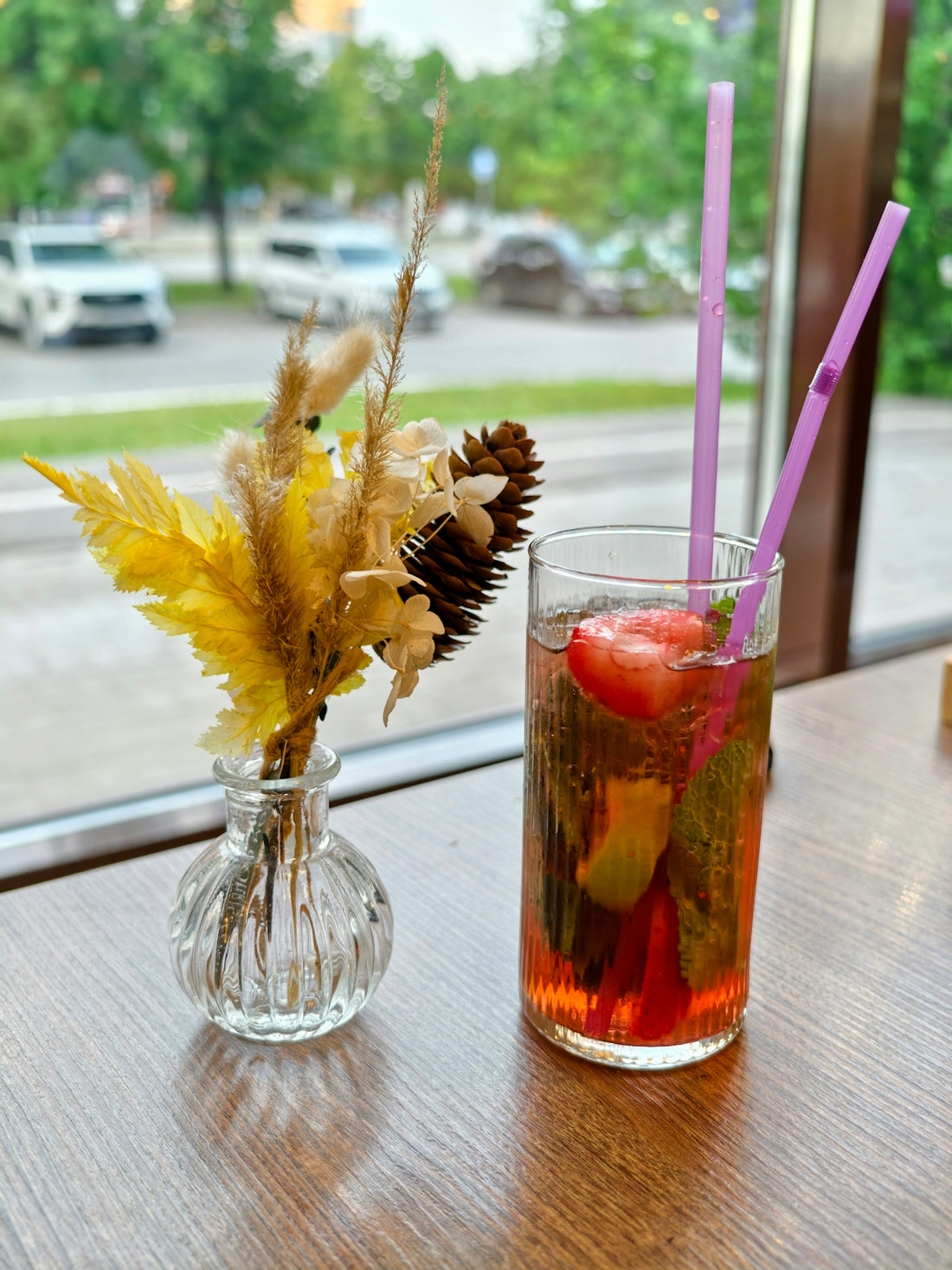 Refreshing strawberry drink with dried flowers on a wooden table